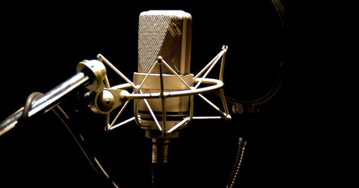 A studio microphone against a dark background.