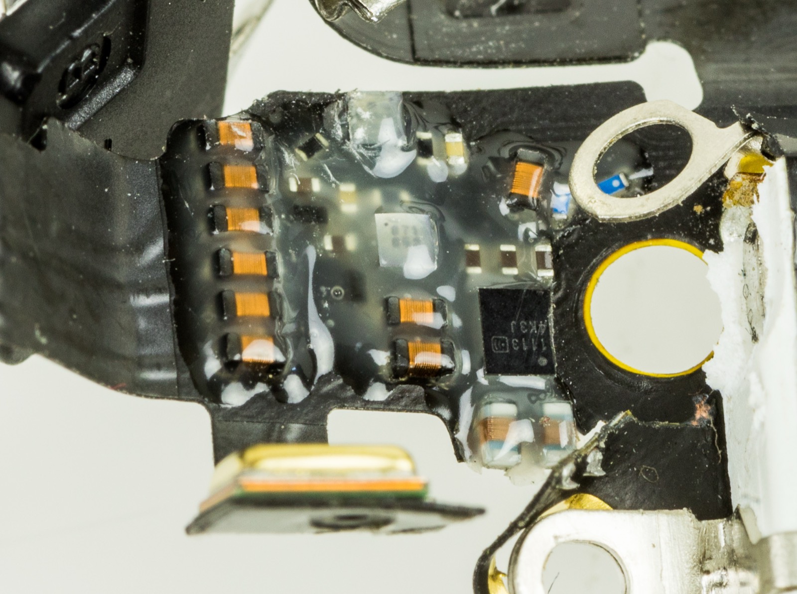 The bottom microphone opening on an iPhone 5s.