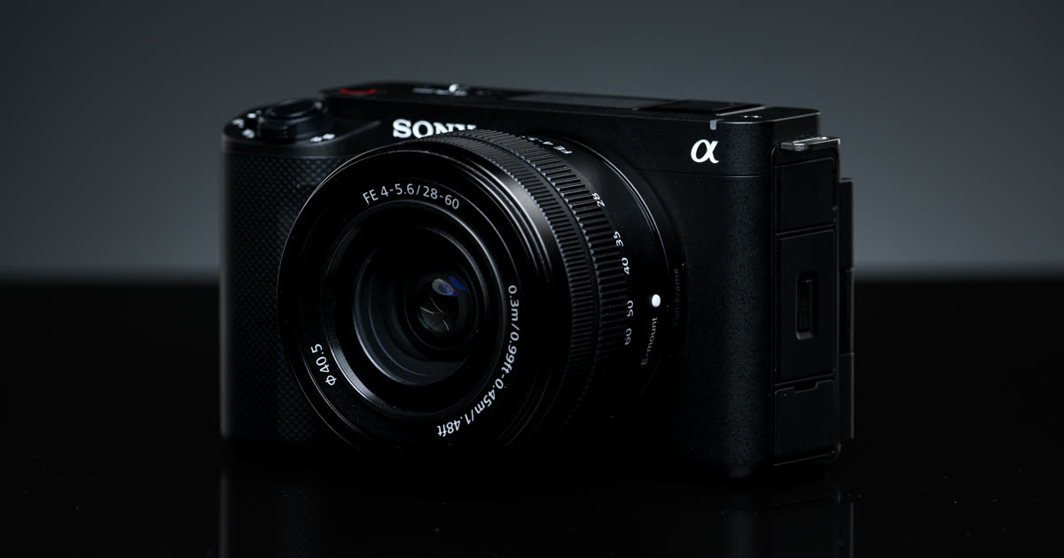 A compact Sony vlogging camera with a zoom lens on a dark surface.